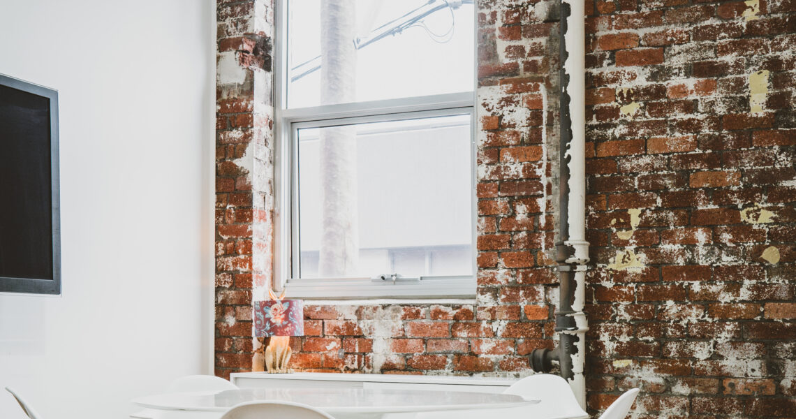 The Leap meeting room at ko&co workhub with white designer chairs, exposed brick walls, and natural light. South Melbourne coworking space for creatives and small business