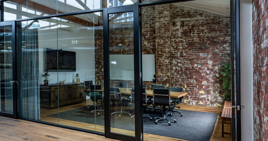 Exterior view through glass walls into The Queen’s Gambit meeting room at ko&co workhub coworking hub in South Melbourne