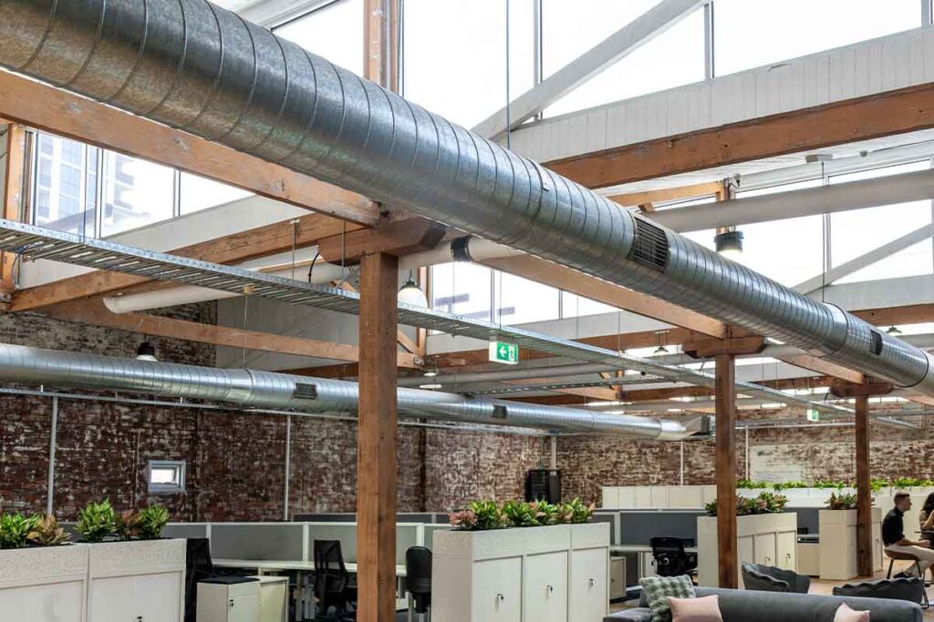 Open plan workspace at ko&co workhub filled with natural light from ceiling-height windows and skylights. South Melbourne coworking space.