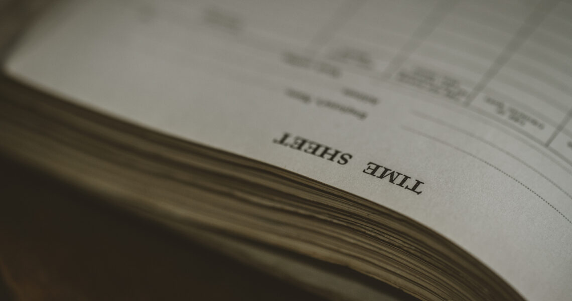 Close-up of a printed timesheet on a wooden desk, symbolising virtual assistant support with admin and marketing tasks. ko&co workhub south melbourne coworking space